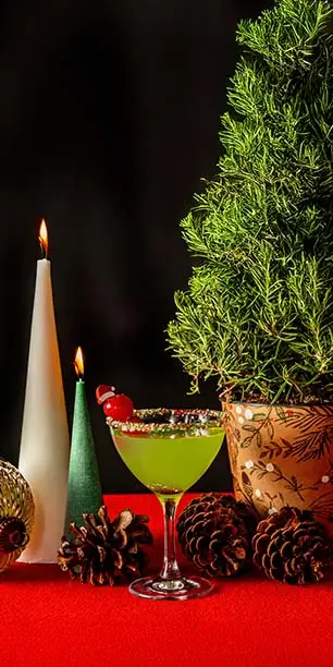 Green holiday cocktail with cherry Santa garnish at Planet Hollywood NYC