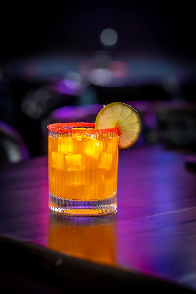 Sweetheart Sparkler mocktail with ice, citrus garnish, and red sugar rim.