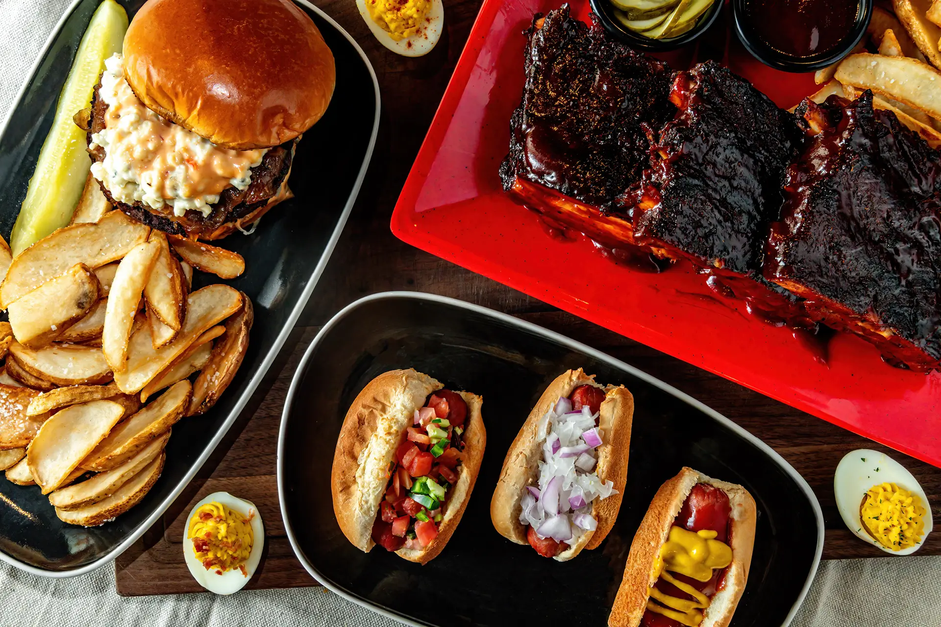 America 250 menu spread with BBQ ribs, burger, fries, deviled eggs, and hot dogs.